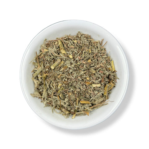 A bowl of dried Wormwood (Ajenjo) leaves, commonly used in herbal medicine.