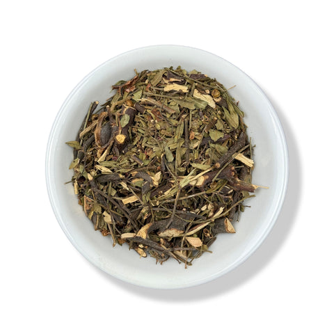 Dried pirul herb pieces in a white bowl on a white background.