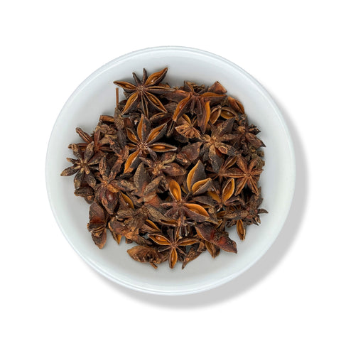 A white bowl filled with star-shaped aniseed spices.
