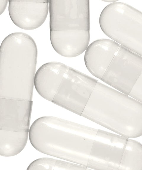 A collection of empty white capsules arranged on a surface.