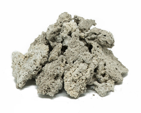 Light gray tequezquite mineral chunks in a loose pile on a white surface.