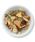A variety of dried herbal tea leaves and pieces in a white bowl.