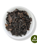 Bowl filled with dried black walnut hull pieces, labeled as bulk herbal product.