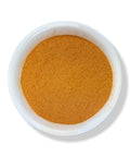 A bowl filled with finely ground orange-brown powder, traditionally used as a herbal supplement.