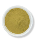 A bowl of fine green powder, representing Chaparral Powder (Polvo De Gobernadora), traditionally derived from the leaves of the Larrea tridentata plant.