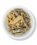 A bowl containing dried pieces of Chaparro Amargo (bitter bark) against a white background.