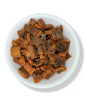 Dried cinchona bark pieces on a white plate.