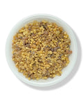 A bowl of beige-colored Frankincense resin beads against a white background.