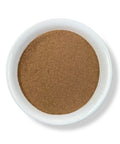 A white bowl filled with finely ground light brown cornsilk powder on a white background.