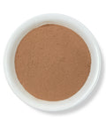 A small white bowl containing brown Cuachalalate powder.