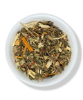 A variety of dried herbal tea leaves and pieces in a white bowl.