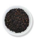 A bowl of whole, dried elderberries.