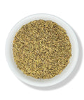 Dried fennel seeds in a white bowl.