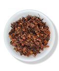 A bowl of dried Tilia Estrella (Flor De Tila) herbs, which appear as small, brownish碎片 with occasional star-shaped flowers.