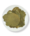 A white plate containing dried heart-shaped leaves of Hoja Santa, also known as Piper auritum.