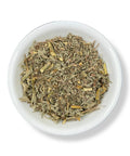 A bowl of dried Wormwood (Ajenjo) leaves, commonly used in herbal medicine.