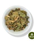 White bowl filled with dried Nispero leaf pieces in bulk packaging, showing natural green leafy herbal tea ingredients on a clean white background
