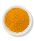 A bowl filled with turmeric powder, with a white background.