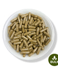 A white bowl filled with green moringa capsules, with a label indicating 'BULK'.