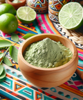 Wooden bowl filled with green Nettle Leaf powder on a colorful patterned cloth with fresh limes in the background