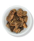 A bowl containing dried pieces of Palo de Vibora (snake herb) against a white background
