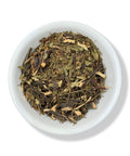 Dried pirul herb pieces in a white bowl on a white background.