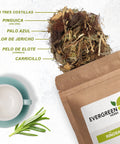 Evergreen Herbs Ríñosan loose-leaf tea spilling from a kraft pouch, with labeled herbal ingredients and a teacup beside it.