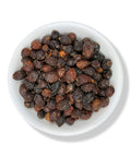 Dried Rose Hips in a white bowl on a white background.