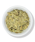 Dried senna leaves in a white bowl.