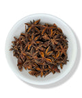 A white bowl filled with star-shaped aniseed spices.