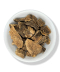 A white bowl filled with dried Tumba Vaquero herbs, which are traditionally used for medicine.