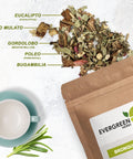 Evergreen Herbs Bronquios herbal blend with labeled ingredients — eucalyptus, palo mulato, gordolobo, poleo, and bugambilia — next to a cup and rosemary sprigs.
