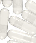A collection of empty white capsules arranged on a surface.