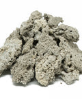 Light gray tequezquite mineral chunks in a loose pile on a white surface.